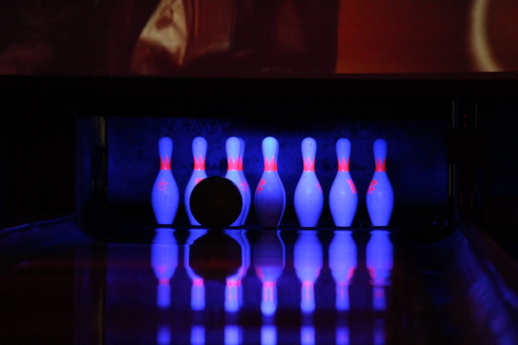 Bowling scene with pins and ball under neon lights, capturing a vibrant nightlife vibe.