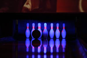 Bowling scene with pins and ball under neon lights, capturing a vibrant nightlife vibe.